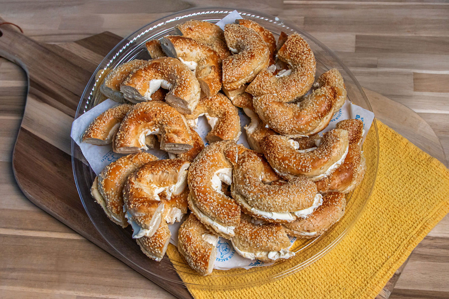 Catering platter of bagels spread with cream cheese.