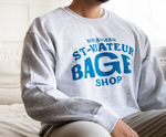 Person wearing a grey crewneck sweater with text "Boulangerie St-Viateur Bagel Shop."